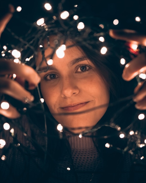 Foto junges mädchen, das weihnachtslichter für den baum vorbereitet