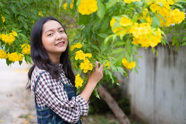 Junges Mädchen des Porträts mit gelben Blumen Asiatisches Mädchen