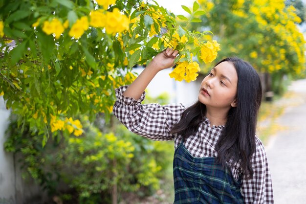 Junges Mädchen des Porträts mit gelben Blumen Asiatisches Mädchen