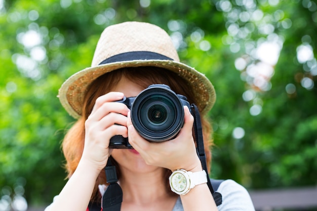 Junges Mädchen Fotograf, der Vintage-Kamera mit weißem Hintergrund hält.