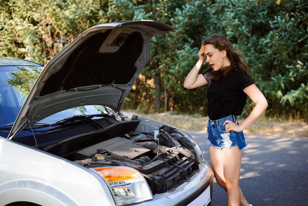 Junges Mädchen fuhr Auto, aber plötzlich ging es kaputt und sie blieb am Wegesrand stehen