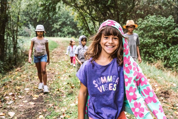 Foto junges mädchen geht mit ihren kleinen entdeckerfreunden durch den wald konzept junger naturliebhaber, die den planeten erde schützen kindheit und natur