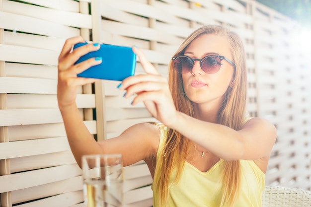 Junges Mädchen im Café, das selfie macht