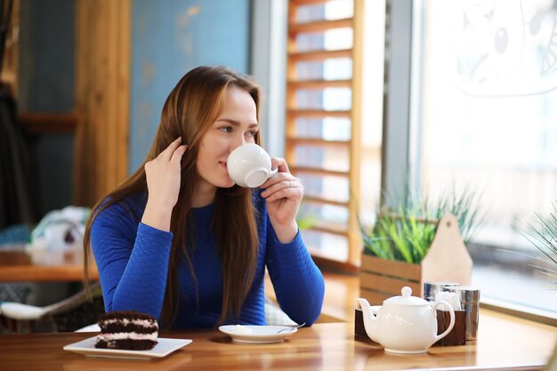 Junges Mädchen im Café sitzt und trinkt Tee