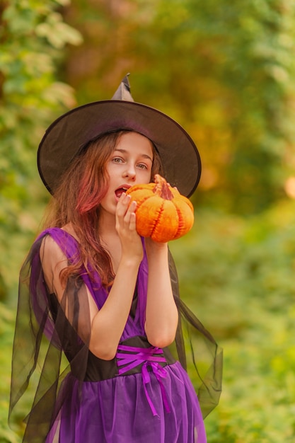 Junges Mädchen im Halloween-Kostüm mit Kürbis.