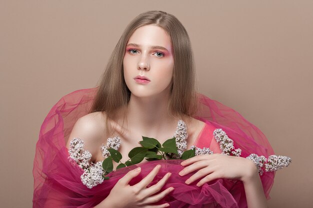 Foto junges mädchen im rosa schleier mit blumen