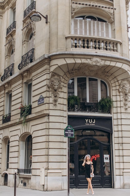 Junges Mädchen im roten Kleid in der Nähe des Eiffelturms in Paris am sonnigen Sommertag