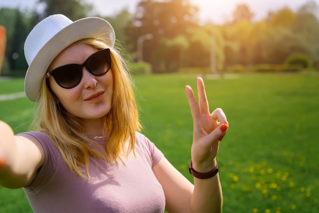 Junges Mädchen im weißen Hut und in der Sonnenbrille