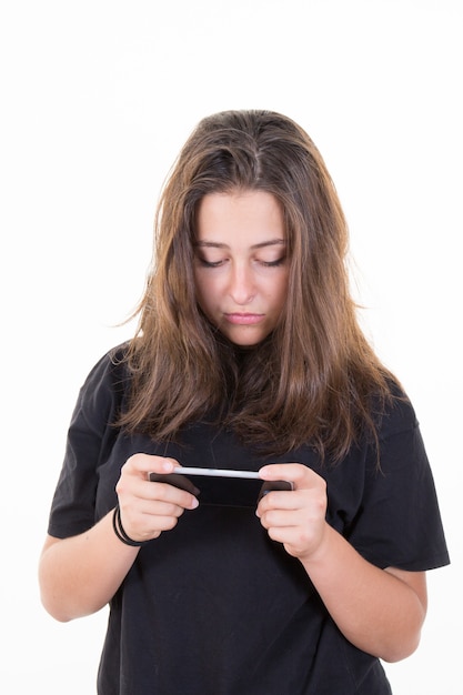 Junges Mädchen in einem schwarzen Hemd, das auf einem mobilen Smartphone simst