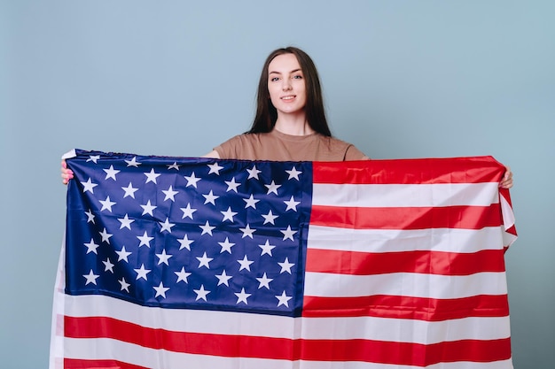 junges Mädchen in einfacher Kleidung hält amerikanische Flagge in ihren Händen Konzept-Unabhängigkeitstag