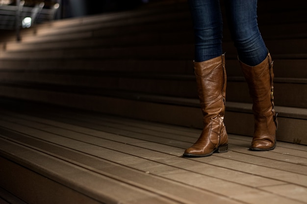 Junges Mädchen in Lederstiefel, die die Treppe hinuntergehen