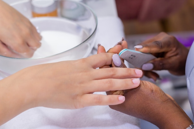 Junges Mädchen lässt sich im Nagelstudio die Nägel machen