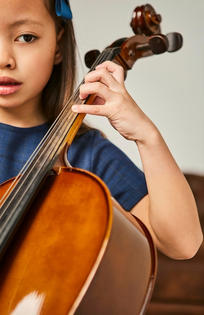 Junges Mädchen lernt, wie man zu Hause Cello spielt