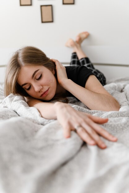 junges Mädchen liegt fröhlich im Bett.