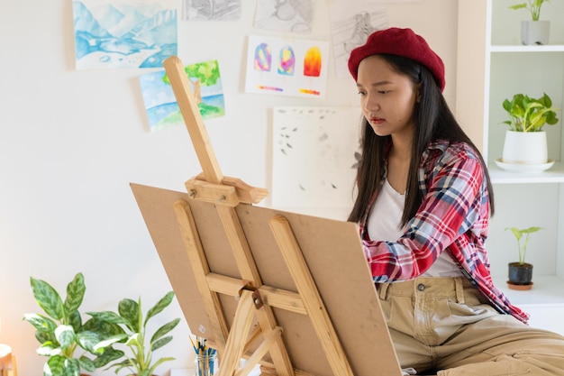 Junges Mädchen malt zu Hause auf Papier HolzrahmenHobby- und Kunststudium zu Hause