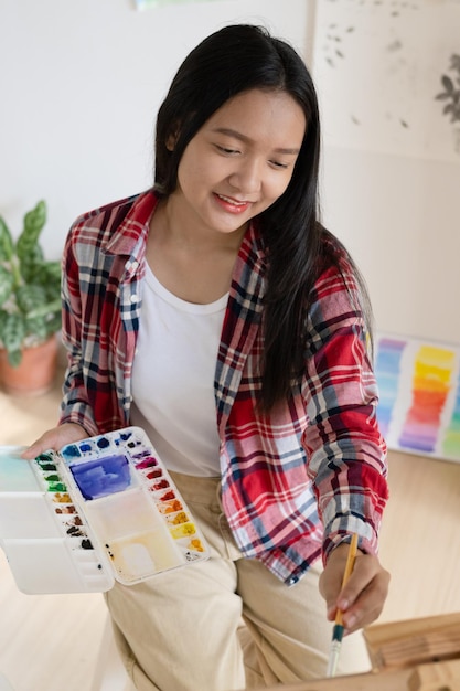 Junges Mädchen malt zu Hause auf Papier HolzrahmenHobby- und Kunststudium zu Hause