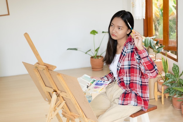 Junges Mädchen malt zu Hause auf Papier HolzrahmenHobby- und Kunststudium zu Hause