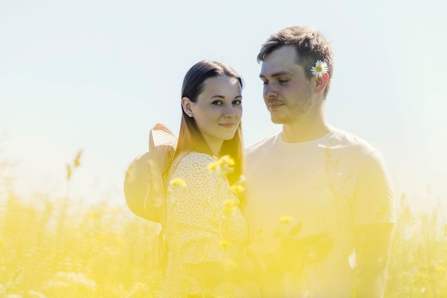 Junges Mädchen mit einem Kerl in einem Feld an einem hellen, sonnigen Tag Liebe und Zärtlichkeit Toller Sommerurlaub in der Natur