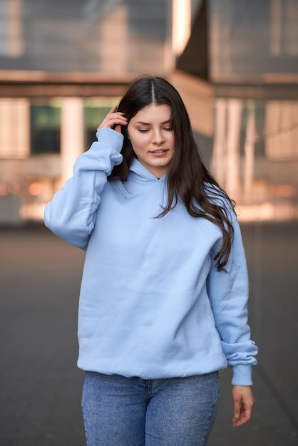 Junges Mädchen mit einem logofreien Hoodie Moderne Markenpräsentation Mockup