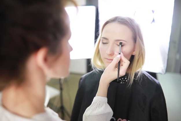 Junges Mädchen mit einem Maskenbildner im Studio vor einem SpiegelxA