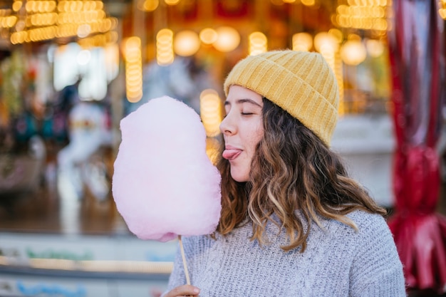 Junges Mädchen mit einer Zuckerwatte an einem Weihnachtsmarkt