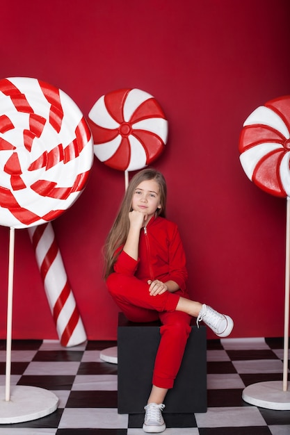 Junges Mädchen mit großen Weihnachtszuckerstangen