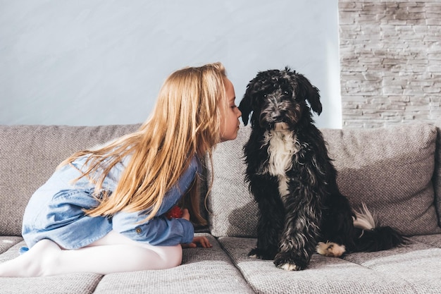 Junges Mädchen mit ihrem Hundefreund spielt zu Hause Freundschaft