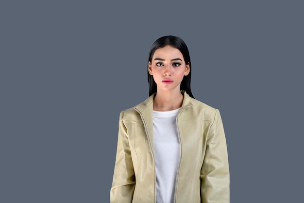 Junges Mädchen mit Jacke auf der Suche nach vorn auf grauem Hintergrund indisches pakistanisches Modell