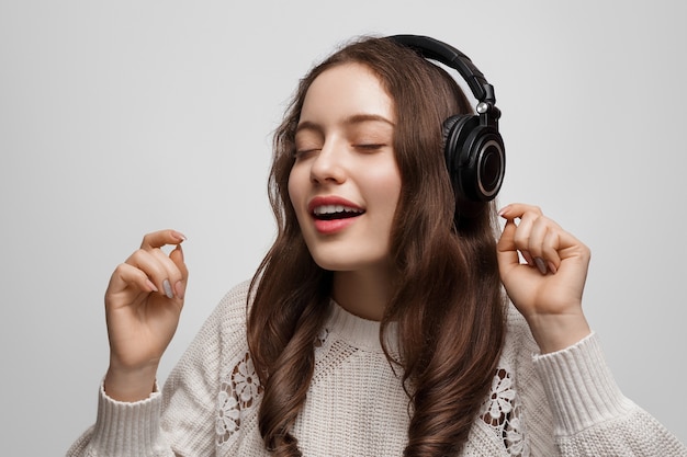 Junges Mädchen mit langen Haaren und Kopfhörern auf, Musik hören