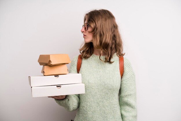 Junges Mädchen mit Pizzen und Burgern nehmen Fast-Food-Konzept mit