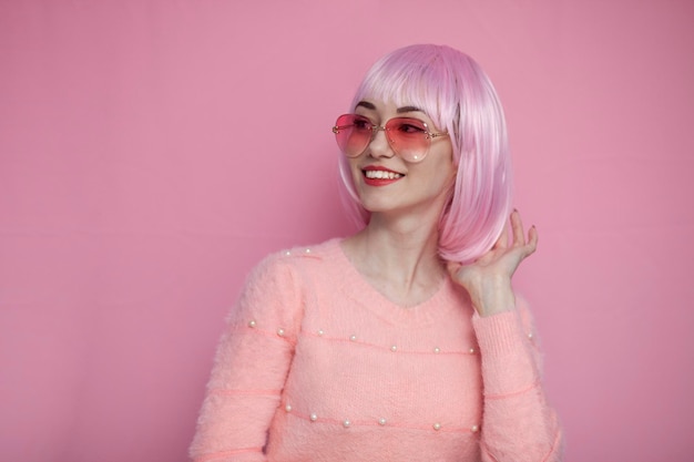 Junges Mädchen mit rosa Haaren glättet ihr kurzes Haar und lächelt