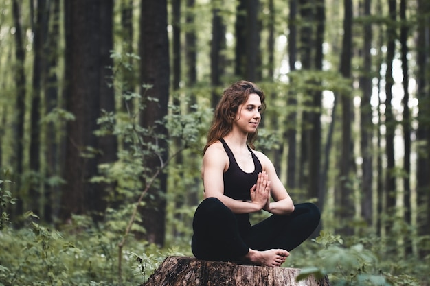 Junges Mädchen praktiziert Yoga im Wald, das Konzept, Privatsphäre und Konzentration, Sonnenlicht zu genießen