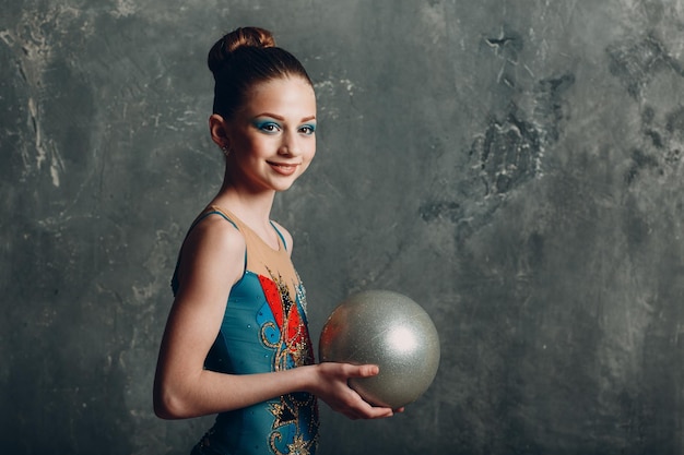 Junges Mädchen professionelle Turnerin Frau Porträt rhythmische Gymnastik mit Ball im Studio