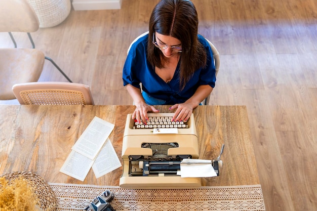 Junges Mädchen schreibt ihren nächsten Roman mit einer alten Schreibmaschine
