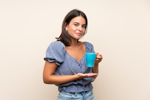 Junges Mädchen über der lokalisierten Wand, die heißen Tasse Kaffee hält