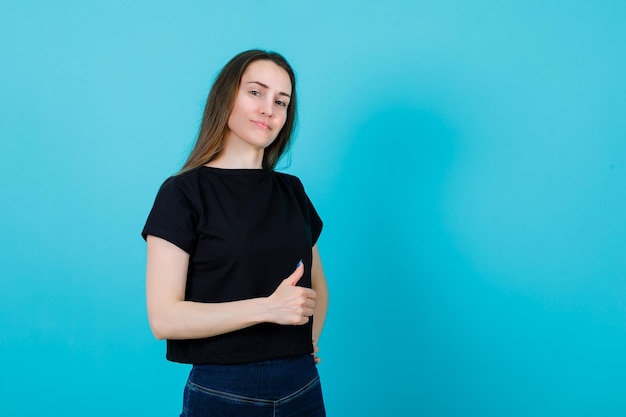 Junges Mädchen zeigt perfekte Geste auf blauem Hintergrund