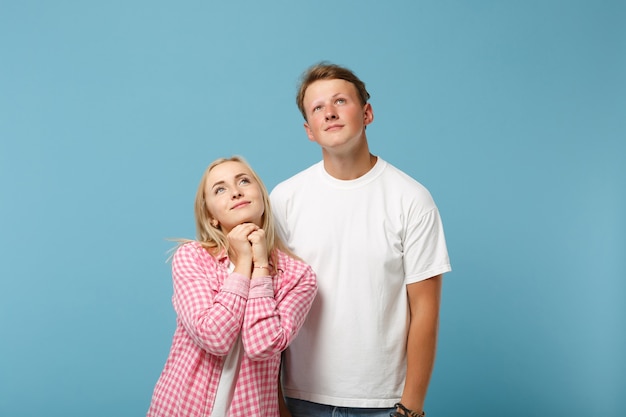 Junges nachdenkliches paar zwei freunde mann und frau in weißen rosa leeren leeren t-shirts posieren