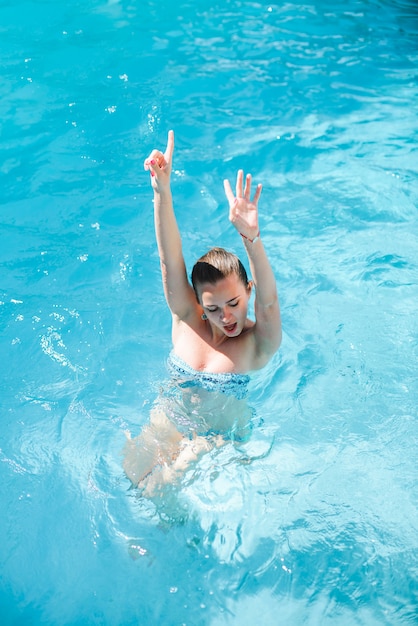 Junges nettes Mädchen hat Spaß am Swimmingpool