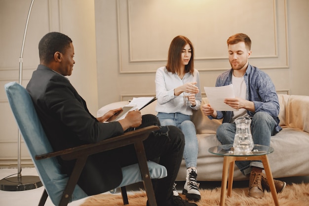 Junges Paar am Pshykologenkabinett. Sie machen einen Test oder füllen die Decke für die Therapie.