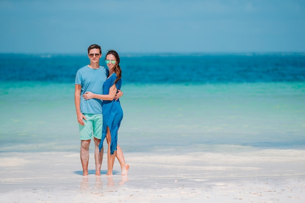 Junges Paar am weißen Strand während der Sommerferien.