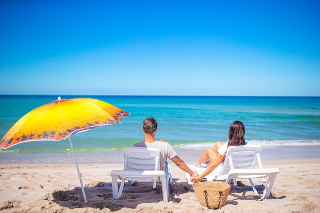 Junges Paar am weißen Strand während der Sommerferien.