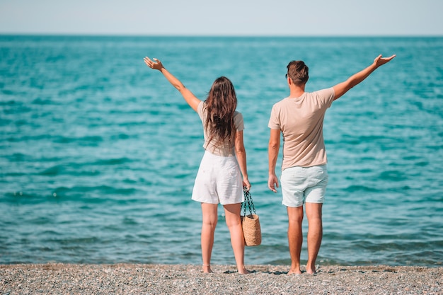 Junges Paar am weißen Strand während der Sommerferien.