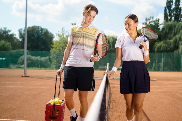 Junges Paar auf Tennisplatz.