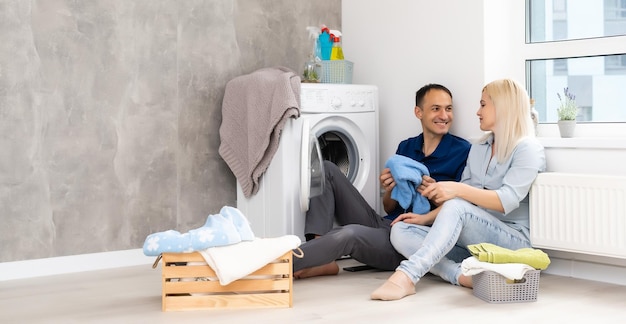 Junges Paar bei der Hausarbeit. Waschküche in neuer Wohnung.