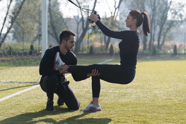 Junges Paar beim Crossfit mit Trx-Fitnessgurten im Stadtparkbereich Training und Training für Ausdauer Gesunder Lebensstil Konzept im Freien