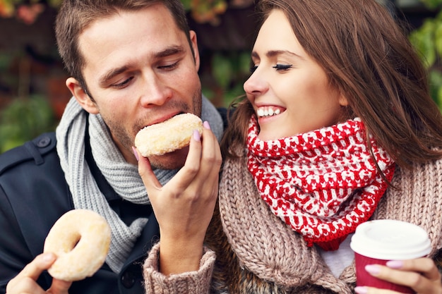 Foto junges paar beim date in der stadt mit kaffee und donuts