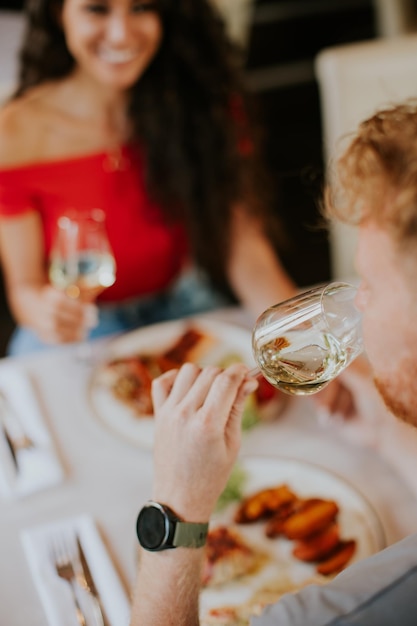 Junges Paar beim Mittagessen mit Weißwein im Restaurant