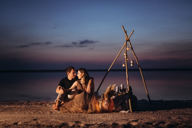 Junges Paar beim Picknick am Strand eines rosa Sees