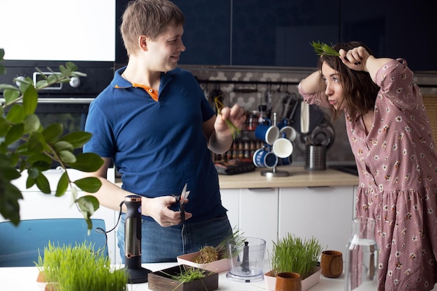 Foto junges paar bereitet grünen weizengrassaft zu, gesundes antioxidatives smoothie-getränk, familienspaß