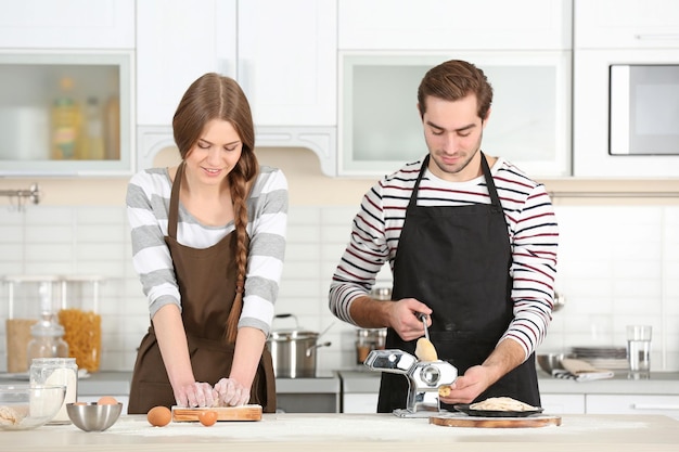 Junges Paar bereitet Pasta am Küchentisch zu